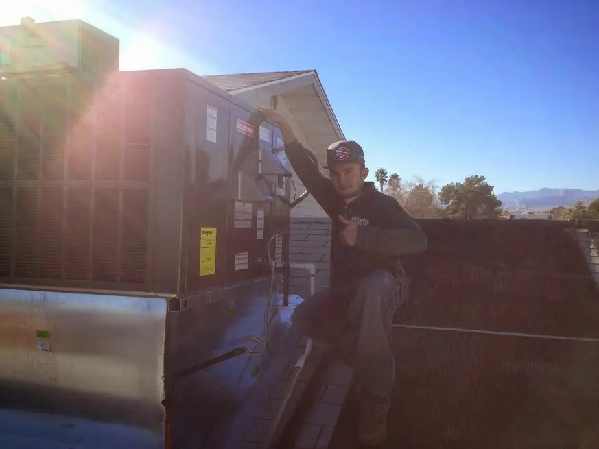 HVAC technician performing HVAC Inspection on a rooftop unit in Carrollton